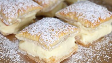 Freshly prepared Vanilla Custard Bars on a cooling rack, showcasing flaky puff pastry layers filled with smooth vanilla custard, dusted with powdered sugar, ready to be served