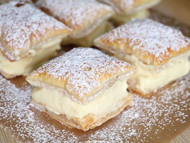 Freshly prepared Vanilla Custard Bars on a cooling rack, showcasing flaky puff pastry layers filled with smooth vanilla custard, dusted with powdered sugar, ready to be served