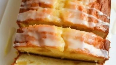 Freshly baked Pineapple Quick Bread on a cooling rack, garnished with pineapple slices and chopped nuts, ready to be sliced and served