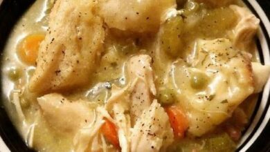 A steaming bowl of Crockpot Chicken and Dumplings, featuring tender chicken and fluffy dumplings, served in a rustic kitchen setting, ready to comfort and satisfy with its hearty flavors