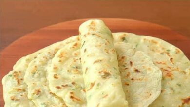 Deliciously golden garlic and butter flatbread freshly made in a rustic kitchen setting, highlighting the appealing texture and inviting aroma of the bread, making it an irresistible addition to any meal
