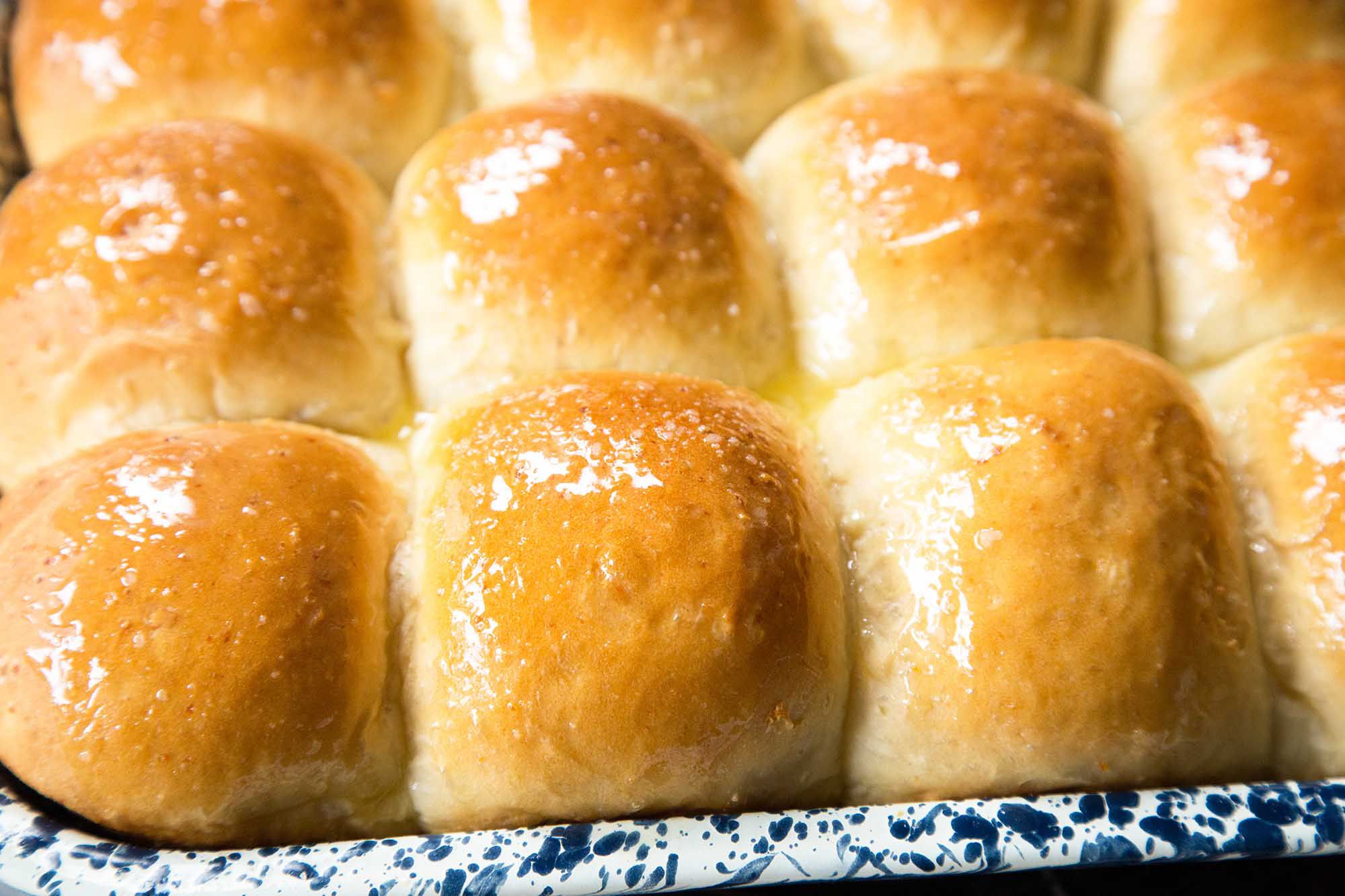 Freshly baked Asian milk bread rolls on a cooling rack, with a golden crust and a soft, fluffy texture, ready to be served