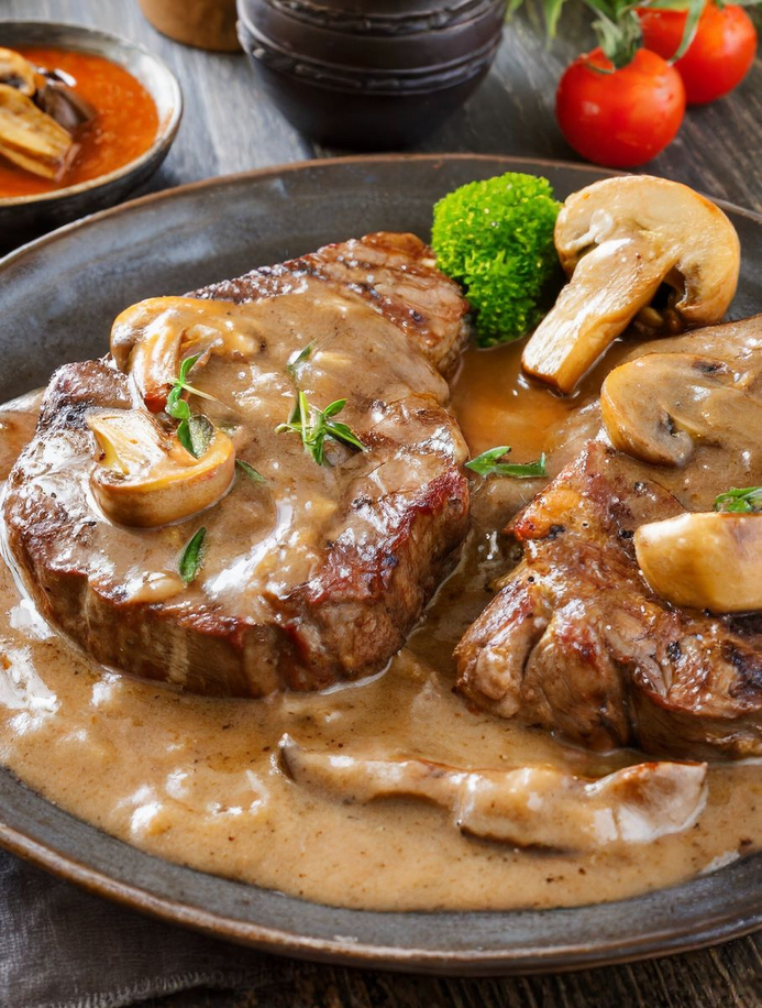 Image of a hearty dish of Slow Cooker Swiss Steak, showcasing tender beef steaks bathed in a rich mushroom sauce, beautifully presented in a rustic slow cooker. The image captures the essence of a home-cooked meal, ideal for cozy family gatherings, emphasizing keywords like 'slow cooker recipes,' 'comfort food,' and 'family dinner ideas' for optimal search engine visibility.