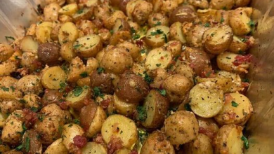 Golden-brown Garlic Parmesan Roasted Potatoes sprinkled with fresh parsley on a rustic wooden table, embodying the perfect blend of crunch and flavor
