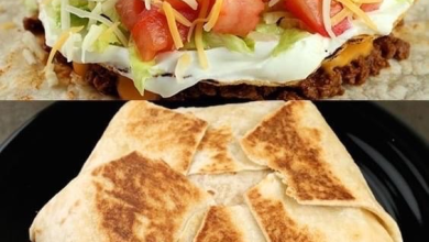 Delicious homemade Crunch Wrap Supreme, golden and crispy on the outside with a melty, savory filling of seasoned beef, nacho cheese, and fresh vegetables, served on a stylish slate serving platter