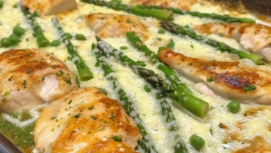 Delicious Caesar Chicken with golden-brown crust and tender asparagus on a stylish ceramic plate, garnished with Parmesan shavings and fresh lemon wedges, ready to delight dinner guests
