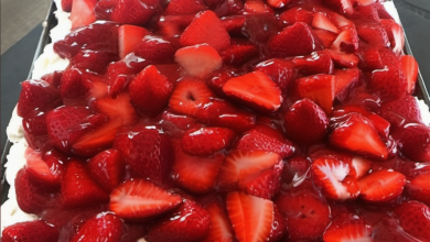 Layered Strawberry Cream Cheese Icebox Cake with Graham Crackers and Whipped Topping in a 13x9-inch baking dish, garnished with fresh strawberries and graham cracker crumbs