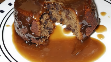 Sticky toffee pudding served warm with a rich toffee sauce, garnished with whipped cream and a sprinkle of chopped nuts