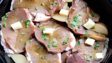 Succulent ranch-seasoned pork chops and tender red potatoes cooked in a crockpot, garnished with fresh parsley.