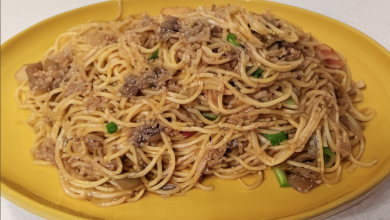 A plate of yakisoba-style spaghetti, garnished with colorful bell peppers and served with chopsticks, on a wooden table Yakisoba Recipe Japanese Noodle Dish Spaghetti Recipe Beef Yakisoba