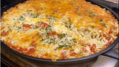 A creamy and cheesy baked spinach spaghetti casserole served steaming in a rustic ceramic dish, topped with golden melted cheese and a sprinkle of fresh herbs.