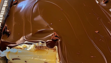 No-Bake Chocolate Eclair Cake sliced into squares, showing the layers of graham crackers, vanilla pudding, and chocolate topping