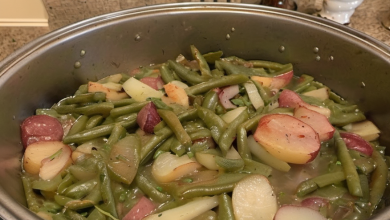 A hearty bowl of Southern Style Green Beans and Red Potatoes, garnished with crispy bacon pieces