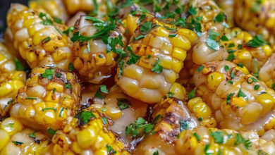 A skillet filled with golden-brown honey butter corn garnished with fresh herbs, showcasing a delightful blend of sweet and savory flavors