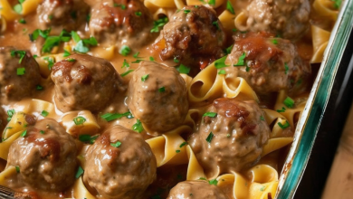 A steaming dish of Swedish meatballs over egg noodles, garnished with fresh parsley, served in a rustic kitchen setting, evoking warmth and homely comfort.
