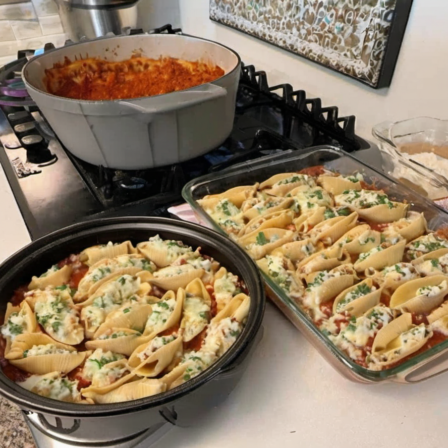 A plate of Taco Stuffed Shells with melted cheese and fresh cilantro garnish, served with a side of diced tomatoes and sliced jalapeños