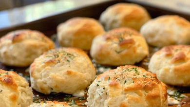 A plate of golden-brown Southern Mozzarella Biscuit Bombs with melted cheese oozing out, garnished with fresh parsley, capturing the warm and inviting essence of homemade Southern cooking
