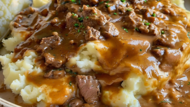 A hearty plate of creamy mashed potatoes topped with savory beef and gravy, garnished with parsley, capturing the essence of comfort food