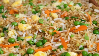 Preparing homemade fried rice with eggs, carrots, and onions in a large wok