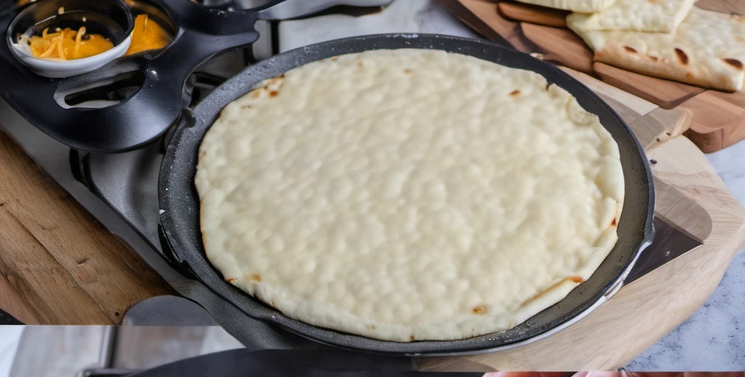 Cheddar cheese flatbread cooking in a pan, showing golden brown crust and melted cheese