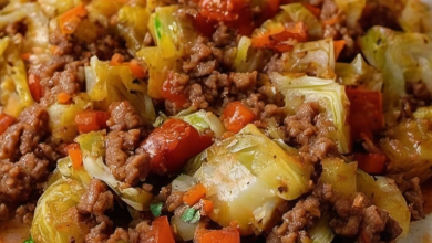 Browning ground beef in a cast-iron skillet for a savory cabbage and beef dish