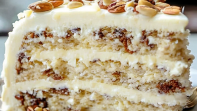 Layering and frosting Quick Italian Cream Cake with creamy cheese frosting and toasted nuts