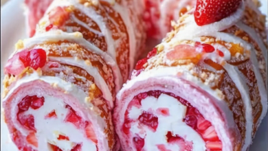 Preparing a rolled-up fruit pastry with fresh strawberries and cream filling