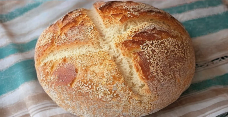 Freshly baked homemade bread loaf with a golden crust cooling on a wire rack