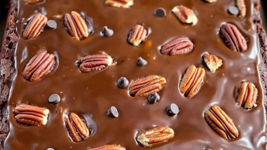 Decadent Texas Turtle Sheet Cake topped with chocolate frosting, pecans, chocolate chips, and caramel drizzle