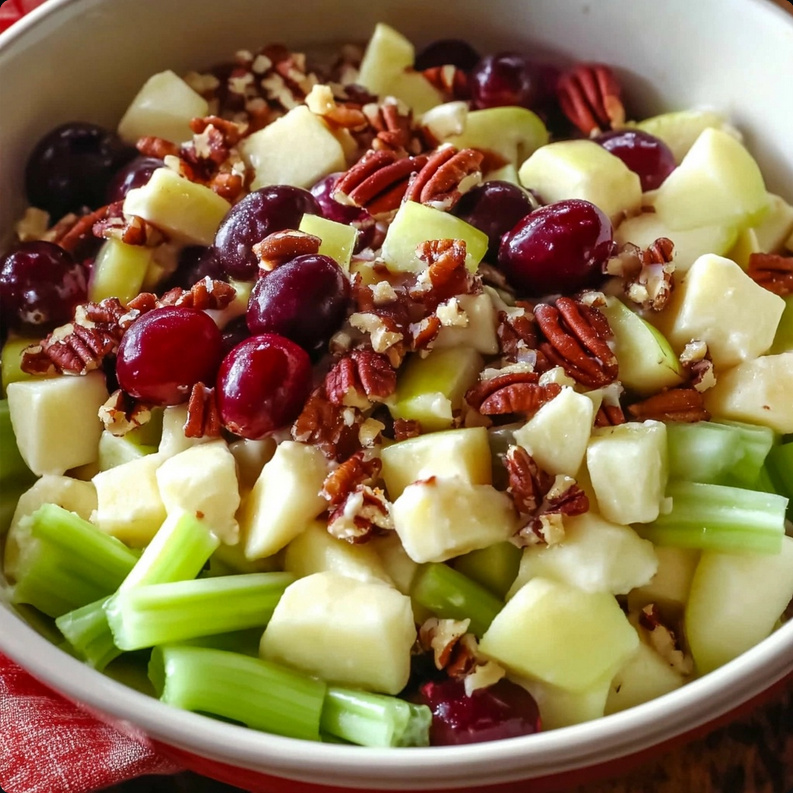 Refreshing apple salad with grapes, pecans, and dried cranberries in a creamy dressing