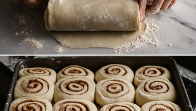 Freshly baked cinnamon-walnut rolls topped with cream cheese frosting, served on a plate.