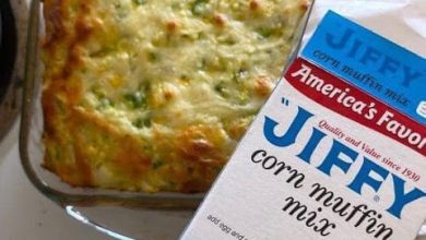 A golden-brown zucchini cornbread casserole, fresh out of the oven, filled with vibrant vegetables and topped with melted cheese