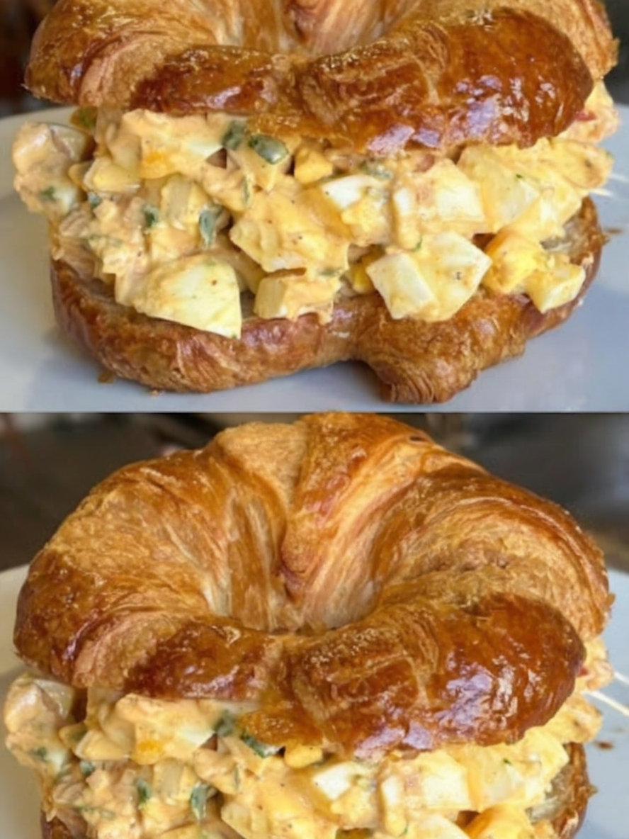 A creamy egg salad served in a bowl, topped with fresh chives, with toasted bread and lettuce wraps on the side