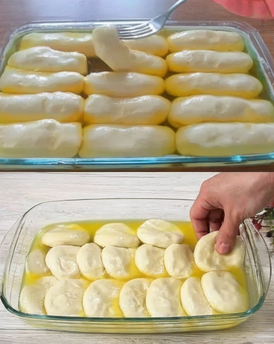 A tray of soft, golden-brown dinner rolls brushed with melted butter, fresh out of the oven