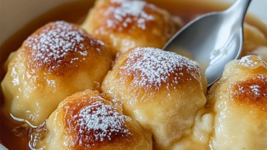 Golden brown apple dumplings drizzled with cinnamon syrup, served with a scoop of vanilla ice cream, offering a cozy and comforting dessert perfect for any occasion