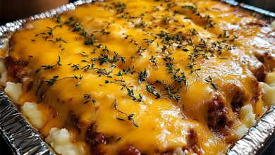 A healthy serving of meatloaf topped with creamy mashed potatoes and melted cheese, garnished with parsley, providing a nutritious meal