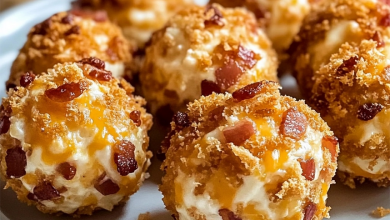 Bite-sized bacon cheddar cheese balls rolled in chopped pecans, served on a wooden board with dipping sauces