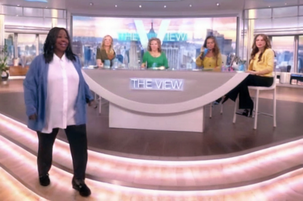 Whoopi Goldberg dramatically exiting the set of 'The View' during a live discussion, reflecting a significant moment of contention over audience etiquette at concerts