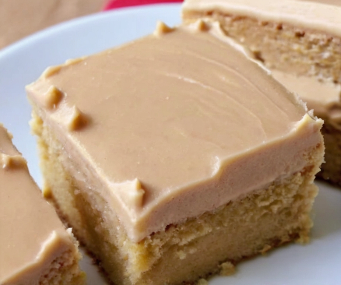 Showcase a perfectly frosted Peanut Butter Sheet Cake with a smooth, creamy peanut butter frosting. Add a sprinkle of chopped peanuts or chocolate chips for garnish. Arrange the cake on a rustic wooden table with a glass of milk in the background to evoke comfort and indulgence.