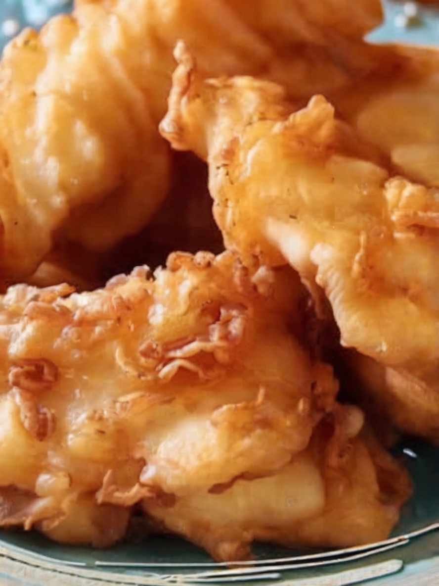Golden-brown fish pieces draining on paper towels, crispy and ready to serve