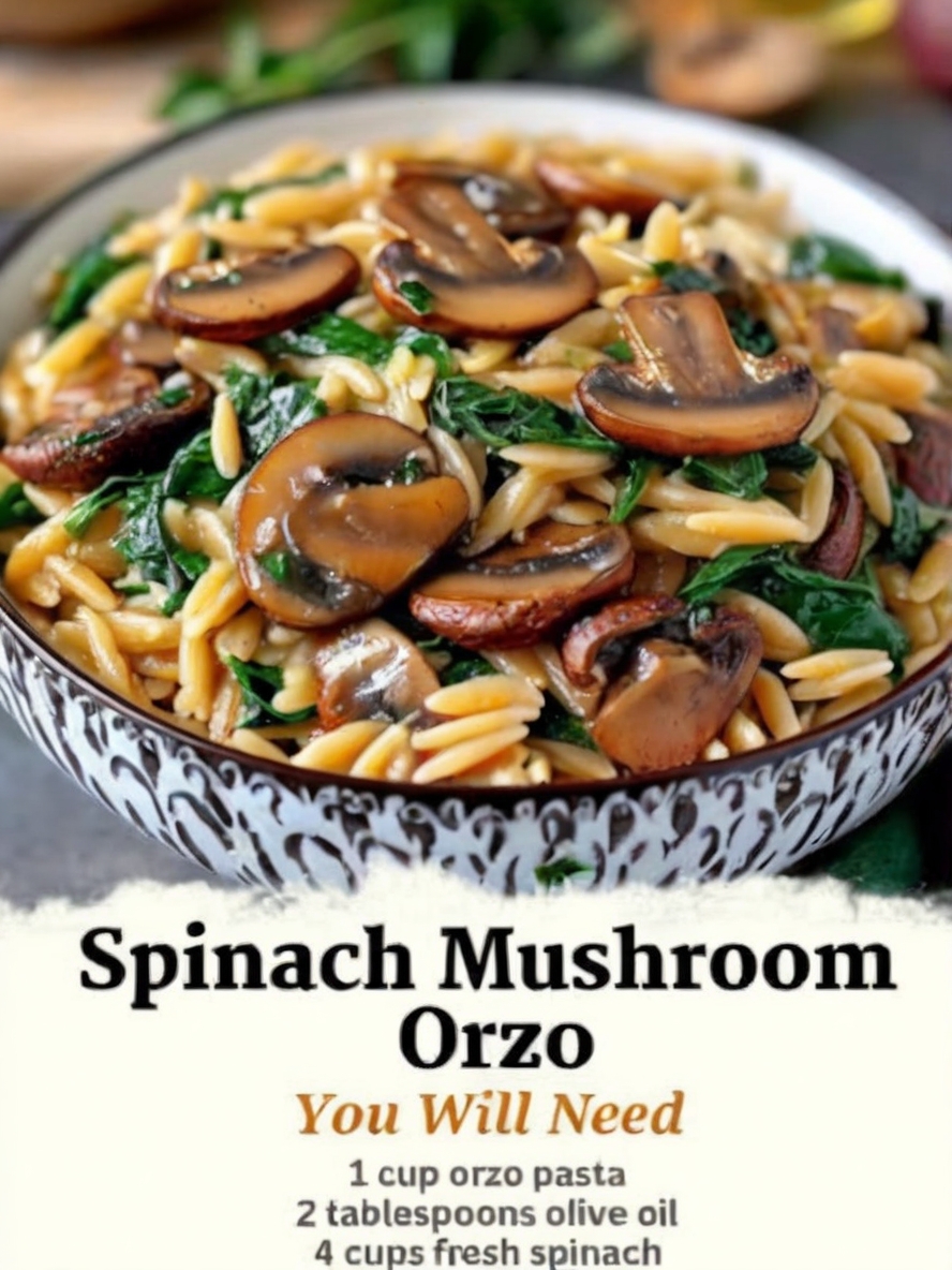 A vibrant plate of Spinach Mushroom Orzo garnished with freshly grated Parmesan and parsley, served alongside a crisp green salad and a slice of crusty bread. The dish is beautifully styled with fresh mushrooms and spinach leaves placed around the plate for an inviting look.