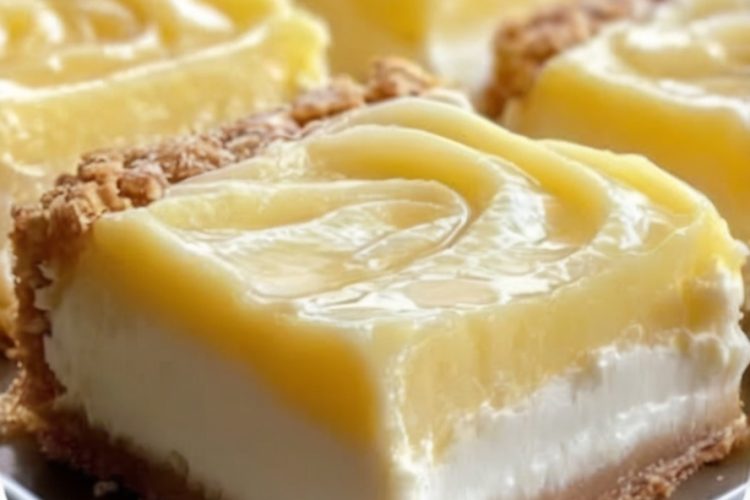 Tangy lemon cream cheese bars with a buttery shortbread crust and a dusting of powdered sugar.