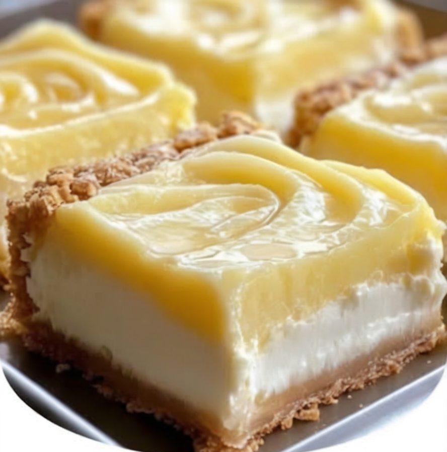 Tangy lemon cream cheese bars with a buttery shortbread crust and a dusting of powdered sugar.