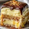No-Bake Chocolate Eclair Cake—a chilled, creamy classic layered with graham crackers, silky vanilla pudding, whipped topping, and a rich chocolate glaze.