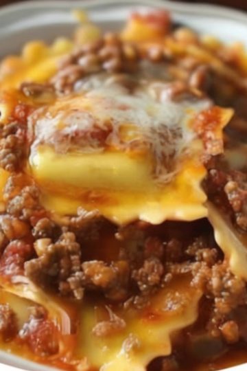 This easy Crockpot Ravioli Lasagna is a cheesy, hearty slow cooker meal that’s perfect for weeknights. Made with frozen ravioli, pasta sauce, and three kinds of cheese, it’s a family dinner winner