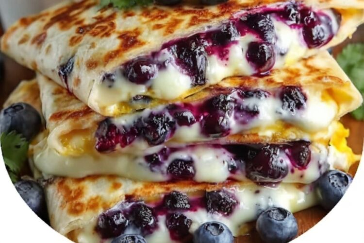 Crispy tortillas stuffed with juicy blueberries and melty cheese, dusted with powdered sugar and syrup — a 10-minute breakfast miracle.