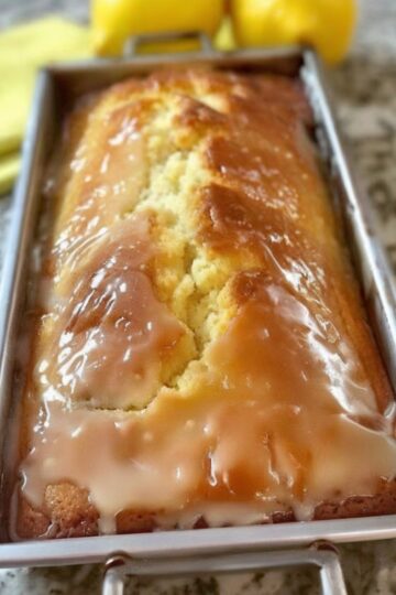 A buttery, moist lemon loaf infused with zesty flavor and topped with a sweet, crunchy citrus glaze.