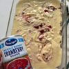 A festive holiday cake with a buttery pecan base, tender vanilla crumb, and joyful cranberry–cream cheese swirls.
