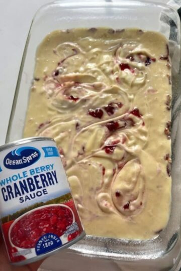 A festive holiday cake with a buttery pecan base, tender vanilla crumb, and joyful cranberry–cream cheese swirls.