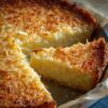 A rich, custard-style coconut pie infused with dark rum and toasted coconut, baked in a buttery crust for a simple yet indulgent tropical dessert.